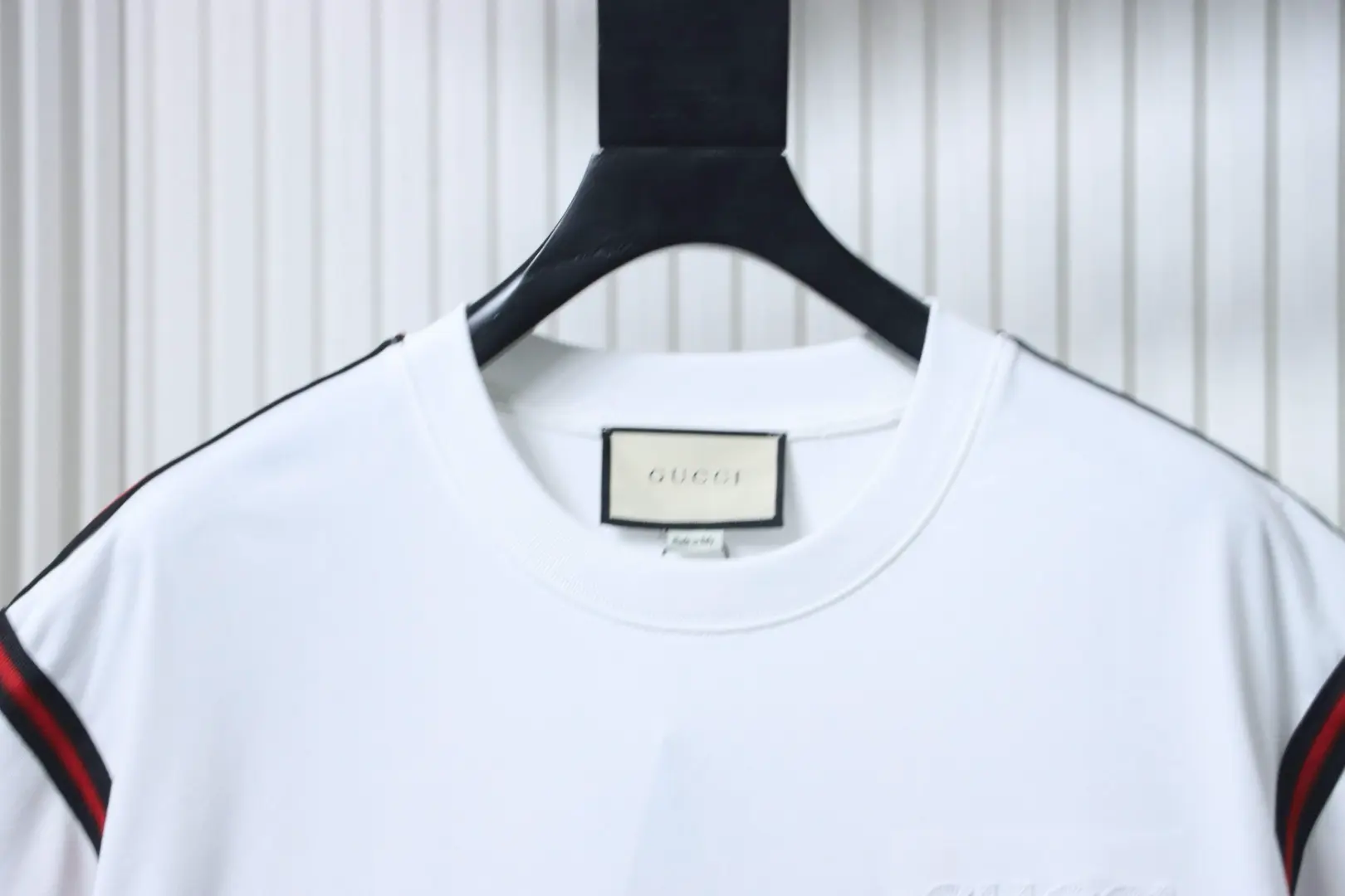 Kurzärmeliges T-Shirt mit rot-grün gesticktem Logo in Schleifenform an Schultern und Ärmeln – Bild 3