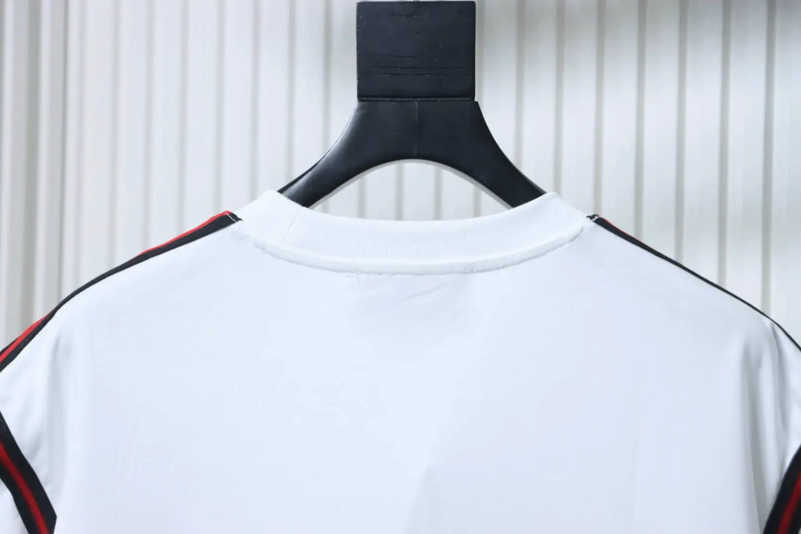 Kurzärmeliges T-Shirt mit rot-grün gesticktem Logo in Schleifenform an Schultern und Ärmeln – Bild 4