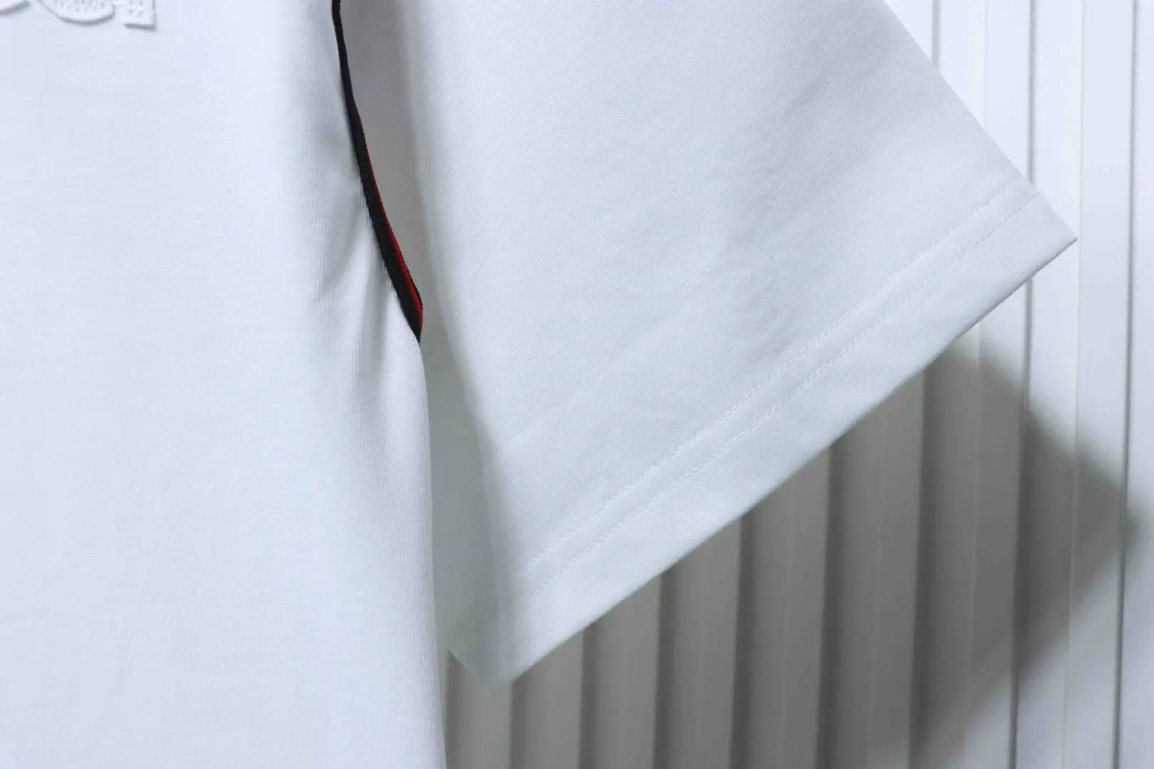 Kurzärmeliges T-Shirt mit rot-grün gesticktem Logo in Schleifenform an Schultern und Ärmeln – Bild 5